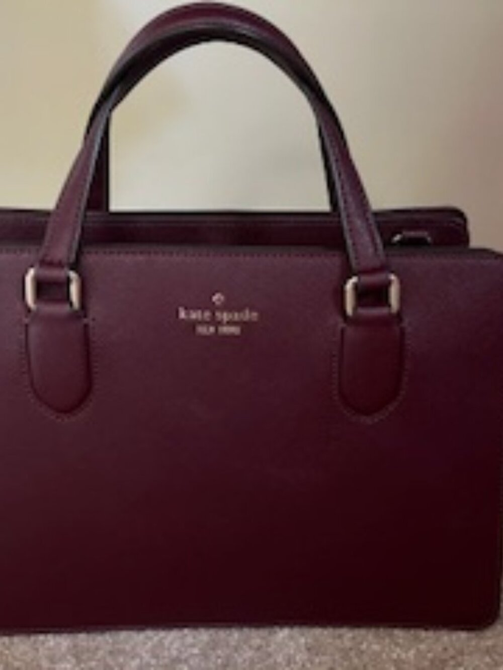 Kate Spade handbag with 2 interior snap pockets and 1 zipper pocket.